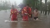彻夜搜救已精疲力尽 他们泡在水中腰系绳索拖着载乡亲的冲锋舟