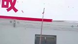 男子用长杆子写墙体字，一笔一划方方正正工工整整