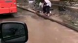 下雨天一位小妹妹在路边清理下水道，满满的正能量