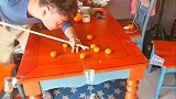 小伙子在家太无聊，结果把小橘子玩成了桌球的样子
