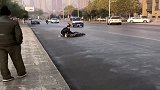 路面结冰老人摔倒，男子跑去扶起老人，还好没受伤
