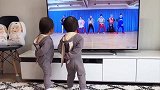 双胞胎宝宝背着手站在电视机前学跳舞，画面把心都萌化了！