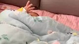 萌娃睡醒后，把手伸出被窝发出起床信号