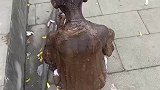 小男孩全身漆黑，不知道的还以为是雕像