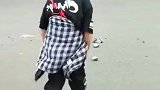 十岁男孩清理路中间碎砖块，妈妈帮着看过往车辆