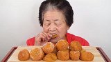 老奶奶吃油炸糯米球，吃起来有点黏牙，老奶奶吃得小心谨慎