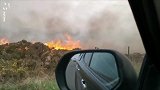 英国一对夫妻驾车穿越着火地区 路旁火焰弥漫浓烟飘进车内