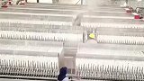 工人手持铁棍左右开弓，将模具上的冰霜清除