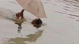 大爷这仰泳的技术很高超啊，一边拿着伞，一边看手机