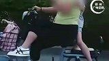 太危险，山东一女子跷二郎腿单手骑车看手机，女儿伏背单腿独立。