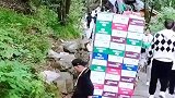 男子背着货物上山，短暂调整后站起出发