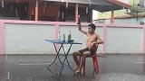 泰国20岁男子暴雨中摆桌吃喝 还邀请路过骑手共饮