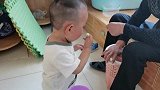 小孔宝看到爷爷在吃东西，赶紧跑过去伸手要，看看他着急的样子