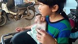 躲在小主人怀里的小猴子，一脸傲娇：零食分我一半