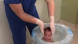 刚刚来到这世界的宝宝，医生将他泡在水里，小家伙觉得好安逸！