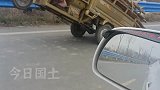 老人骑三轮车拉柴火翘头腾空，好心男子路过下车帮忙