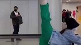 一群女子机场电梯上练劈叉，后方路人大哥突然间走不动了