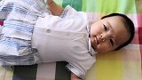 两个月的小宝宝躺在床上，一个人玩得自娱自乐的，小模样好萌！