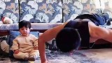 爸爸在客厅做俯卧撑，宝宝看到后立马跟着一起，这画面看着好治愈