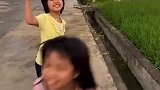 小妹妹走路玩手机，还好有小姐姐提醒，不然小妹妹就要掉水沟里