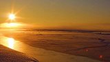 新疆零下23度不冻河似仙境：夕阳染红河面 雾气笼罩似仙境