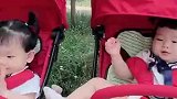 双胞胎姐妹俩，这是咋地啦，一坐上推车就浑身刺挠似一直翻腾