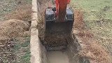 男子开挖掘机清理水道，过程很轻松