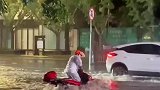 大叔骑摩托车在暴雨中摔倒