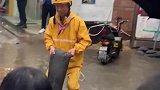 大雨过后地上积水淹没，外卖小哥不顾自己双脚湿透，搬起沙袋铺路