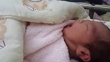 刚出生的女儿睡醒后,打了个喷嚏就开始寻乳，可把这小宝宝给忙坏