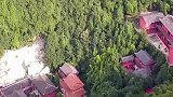 一座房子落山间，四面环山的美景