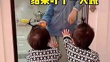 哥哥拿着橘子故意逗一下双胞胎兄弟