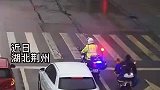 交警等红灯，顺手帮小女孩披好雨衣