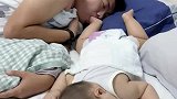 爸爸和宝宝一起睡觉，宝宝把脚伸到爸爸嘴里