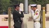 执勤哨兵调整擦汗，身穿厚重礼服和帽靴，动作细微不失威仪