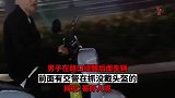 男子在路口提醒后面车辆，前面有交警在抓没戴头盔的