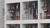 拍男寝阳台“救灾”现状，男生们打伞拿盆卖力往楼下舀水