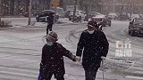 雪天两位老人携手过马路