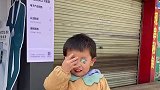 孩子把贴纸贴在眼睛上面，撕出了痛苦面具依然保持微笑