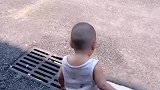 萌娃光脚在柏油路上被烫到踮脚
