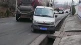 挂车挡在前面过不去,面包车直接开到马路牙子上