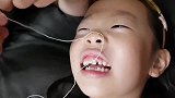 小女孩换乳牙，薅住绳子不敢拽，气得冲爸爸发火哇哇大哭，太逗了