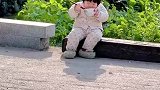 萌娃坐在路边干饭，自顾自埋头猛吃，无忧无虑的样子