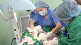 剖腹产成功将胎儿取出，宝宝躺在妈妈身边撅起小嘴亲了一口妈妈