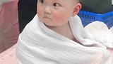 刚洗完澡的宝宝披着浴巾，真像个小天使，呆萌的样子好可爱！