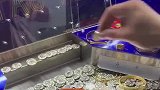 男子将游戏币放在投币机上