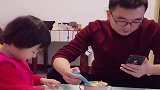 爸爸边玩手机边喂女儿吃饭，心不在焉，都喂到老婆嘴里了