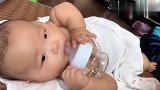 100天的小宝宝自己抱着奶瓶喝水，小模样好萌，这也太乖巧吧！