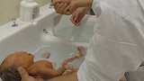 护士指导新手妈妈给宝宝洗澡，妈妈笨手笨脚的，宝宝全程在哭