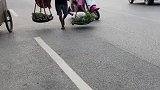 老人清晨担着菜去集市，身兼重担仍然精神矍铄！